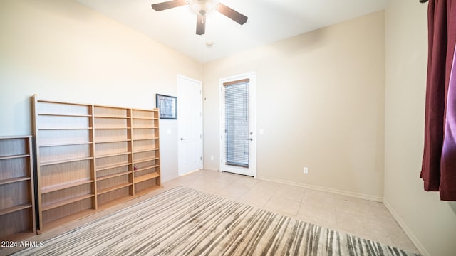 tiled spare room featuring ceiling fan