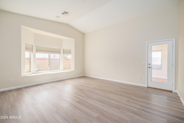 empty room with lofted ceiling and light wood-type flooring