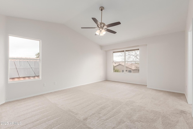 empty room with vaulted ceiling, light carpet, baseboards, and ceiling fan