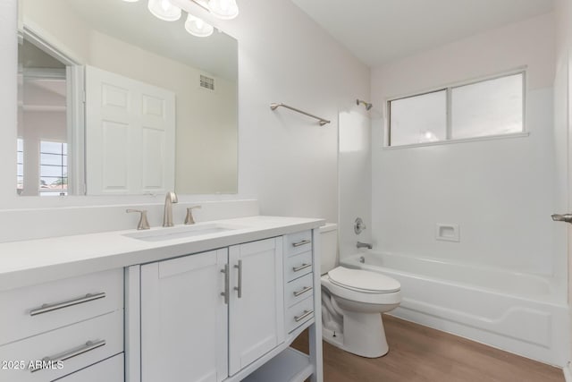 bathroom featuring visible vents, toilet, shower / tub combination, wood finished floors, and vanity