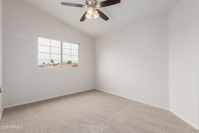 carpeted empty room featuring baseboards, lofted ceiling, and ceiling fan