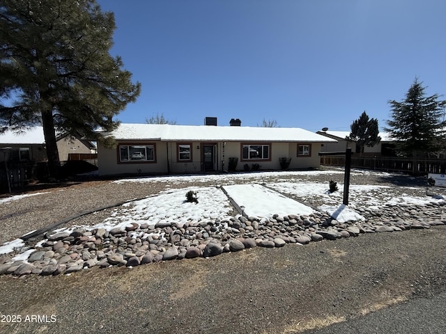 view of front of home featuring stucco siding and fence