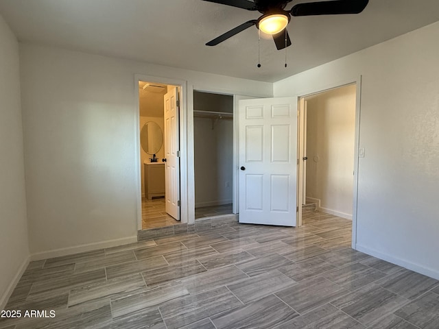 unfurnished bedroom with connected bathroom, wood finish floors, baseboards, ceiling fan, and a closet