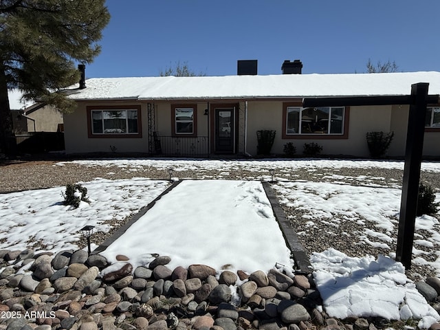 view of front of property with stucco siding and a chimney