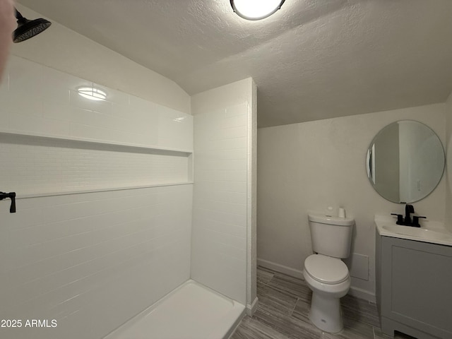 bathroom with toilet, a textured ceiling, wood finished floors, a shower, and vanity