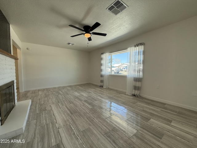 unfurnished living room with visible vents, baseboards, a brick fireplace, and a ceiling fan