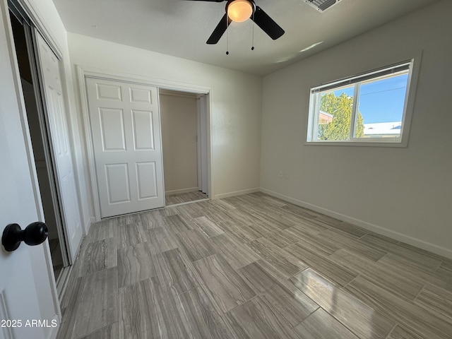 unfurnished bedroom featuring a ceiling fan, light wood-style floors, baseboards, and a closet