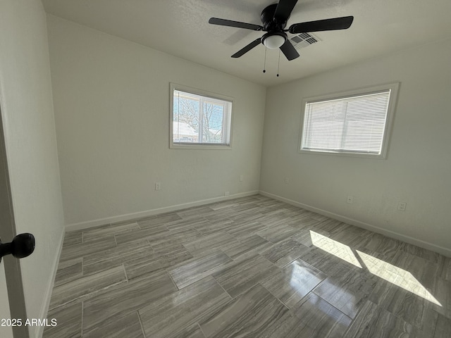 empty room featuring visible vents, baseboards, and a ceiling fan