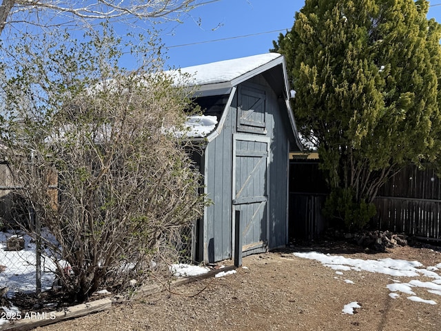 view of side of property with a storage shed, fence, and an outdoor structure