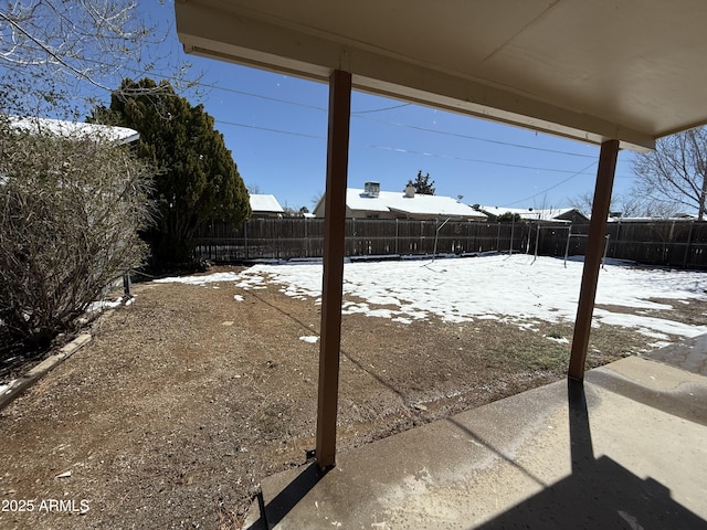 yard layered in snow with a fenced backyard