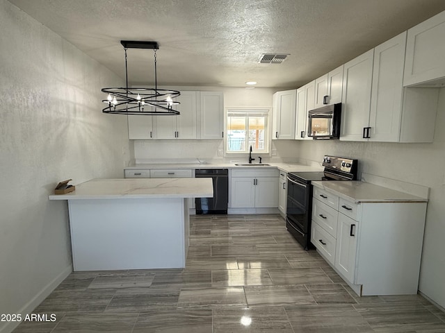 kitchen with white cabinetry, black appliances, visible vents, and a sink