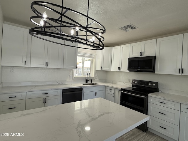 kitchen featuring visible vents, white cabinetry, black appliances, and a sink