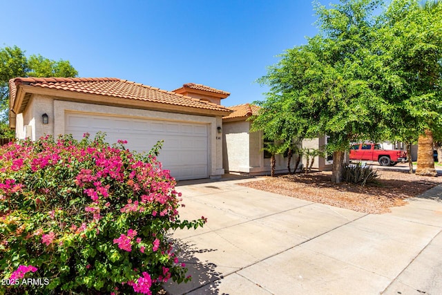 8341 W Cypress St, Phoenix, AZ 85037 - mediterranean / spanish-style house with driveway, stucco siding, a garage, and a tiled roof