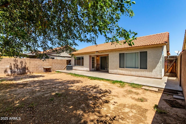 8341 W Cypress St, Phoenix, AZ 85037 - rear view of house featuring a tile roof, stucco siding, a fenced backyard, and a patio