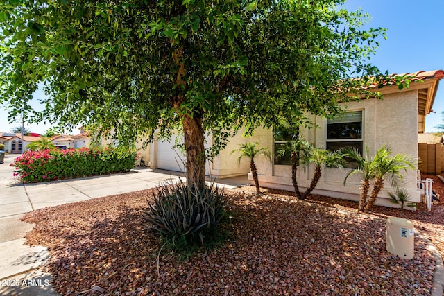 8341 W Cypress St, Phoenix, AZ 85037 - obstructed view of property featuring driveway, stucco siding, and a garage