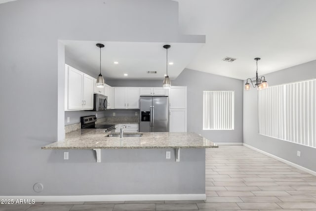 8341 W Cypress St, Phoenix, AZ 85037 - kitchen with stainless steel appliances, a peninsula, lofted ceiling, light stone countertops, and white cabinetry