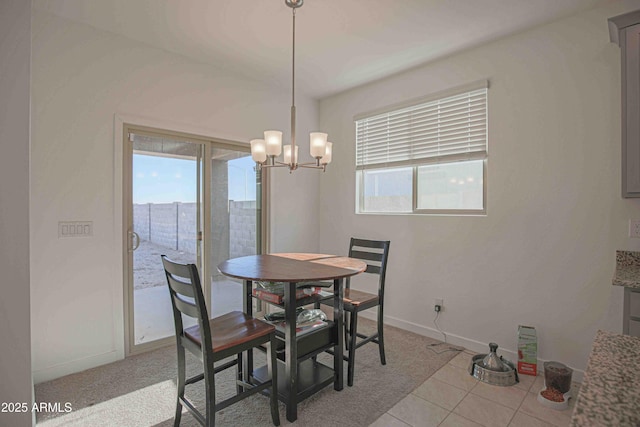 tiled dining room with an inviting chandelier