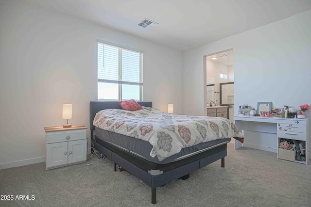 bedroom featuring light carpet and connected bathroom