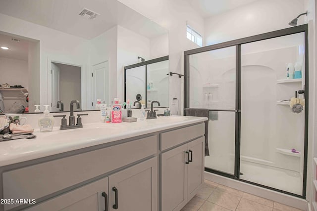 bathroom with tile patterned flooring, vanity, and walk in shower