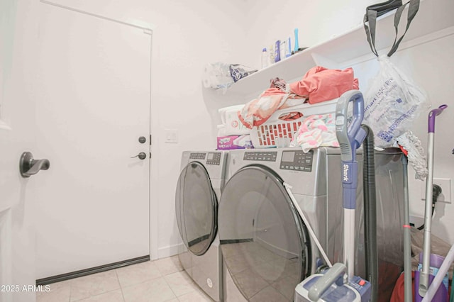 laundry room featuring washing machine and dryer and light tile patterned floors