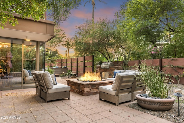 7117 E Rancho Vista Dr Unit 1012, Scottsdale, AZ 85251 - patio terrace at dusk featuring a patio area, area for grilling, and an outdoor fire pit