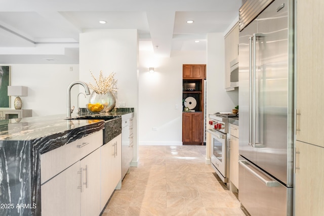 7117 E Rancho Vista Dr Unit 1012, Scottsdale, AZ 85251 - kitchen featuring high quality appliances, dark stone counters, a sink, recessed lighting, and baseboards