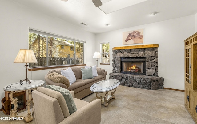 living room featuring plenty of natural light, visible vents, a ceiling fan, and a fireplace