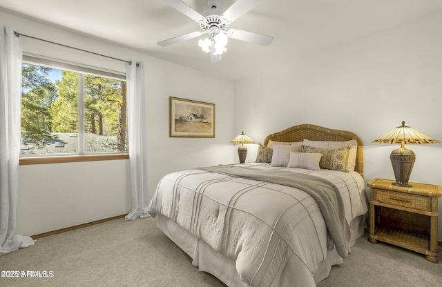bedroom featuring light carpet, baseboards, and ceiling fan