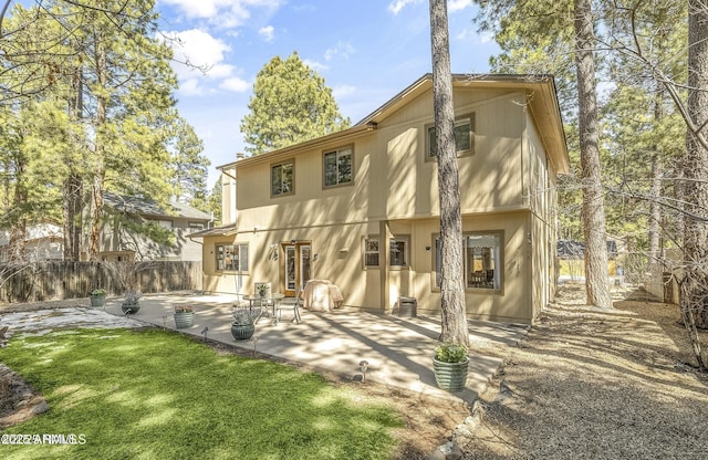 rear view of property featuring cooling unit, a lawn, fence, and a patio