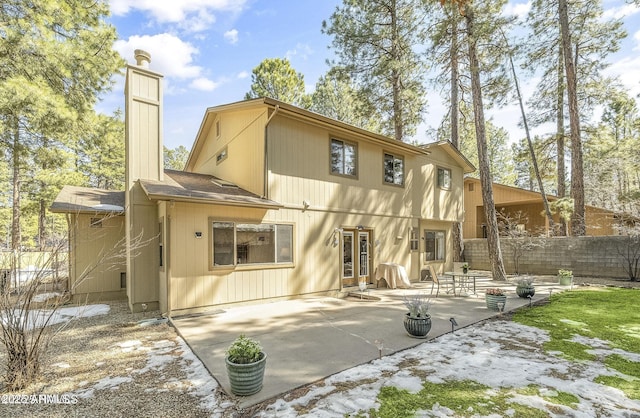 rear view of property with a patio, a chimney, and fence