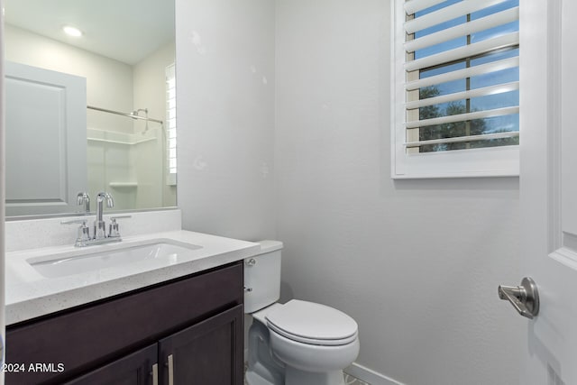 bathroom featuring vanity, toilet, and walk in shower