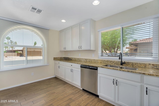 kitchen featuring dishwasher, a sink, white cabinetry, baseboards, and light wood-style floors