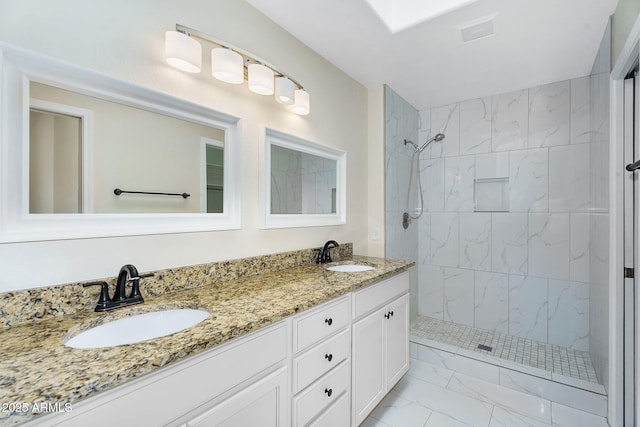 bathroom with marble look tile flooring, a tile shower, and double vanity