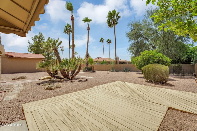 wooden deck with a fenced backyard