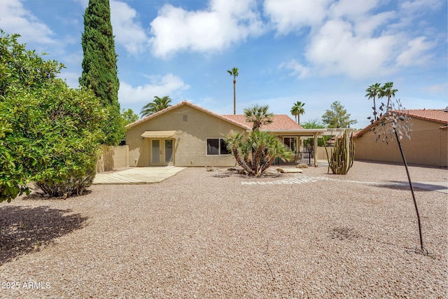 back of property featuring stucco siding, fence, a patio, and french doors