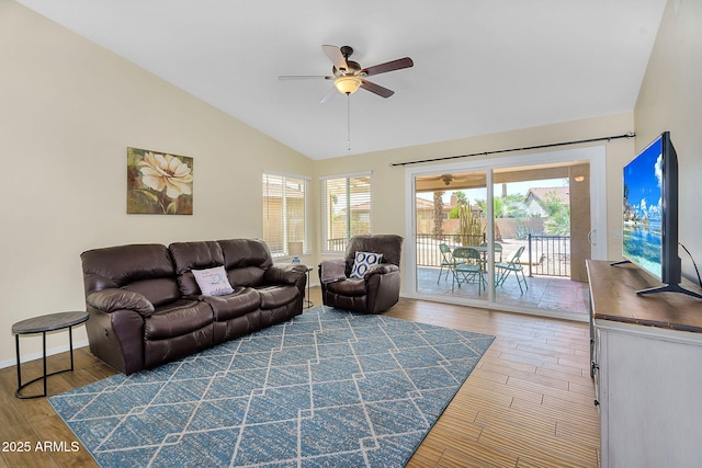 living area featuring vaulted ceiling, a ceiling fan, wood finished floors, and baseboards