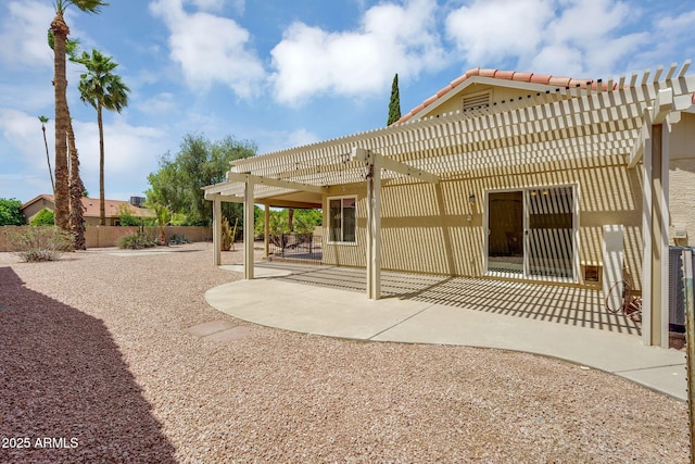 rear view of house featuring a pergola, fence, a patio area, a tile roof, and stucco siding