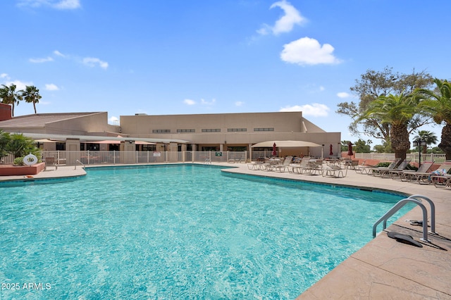 community pool with fence and a patio