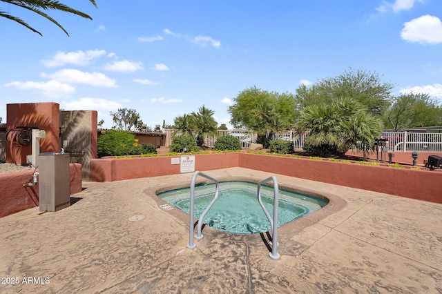view of pool with a hot tub and fence