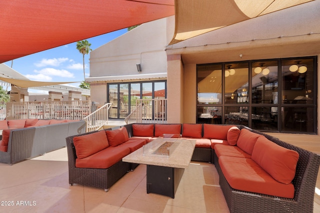 view of patio with an outdoor living space with a fire pit