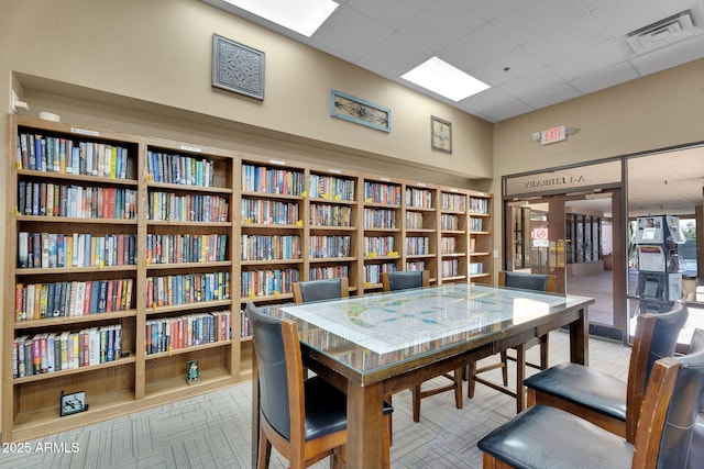 office featuring bookshelves and a drop ceiling
