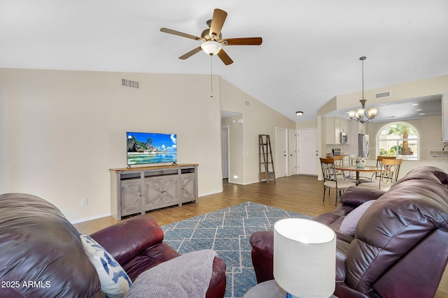 living room with ceiling fan, vaulted ceiling, a chandelier, wood finished floors, and baseboards