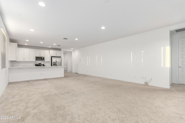 unfurnished living room featuring light carpet