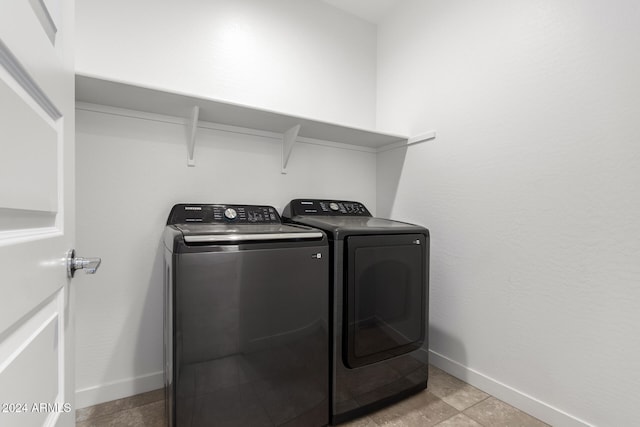 clothes washing area featuring washer and dryer and light tile patterned floors