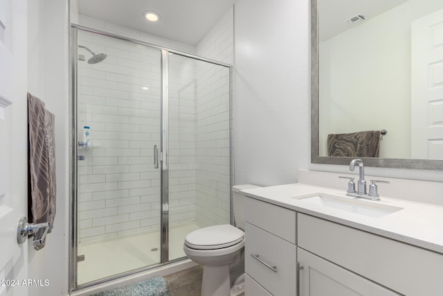 bathroom with vanity, tile patterned flooring, toilet, and an enclosed shower