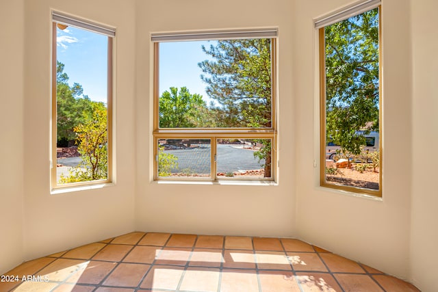 unfurnished room with a wealth of natural light and light tile patterned flooring