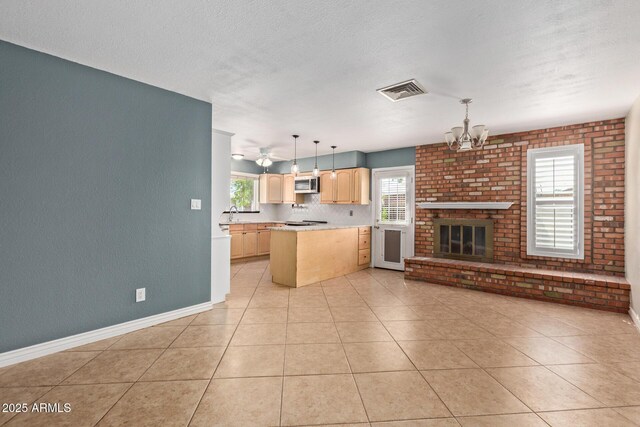 2161 E Harmony Cir, Mesa, AZ 85204 - kitchen featuring stainless steel microwave, light brown cabinetry, a chandelier, light countertops, and pendant lighting