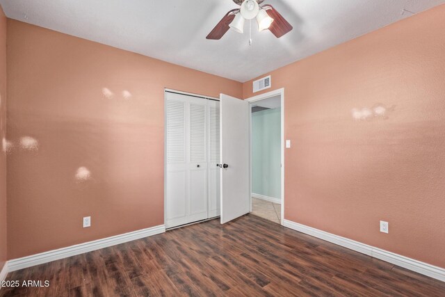 2161 E Harmony Cir, Mesa, AZ 85204 - unfurnished bedroom featuring wood finished floors, a closet, and a ceiling fan