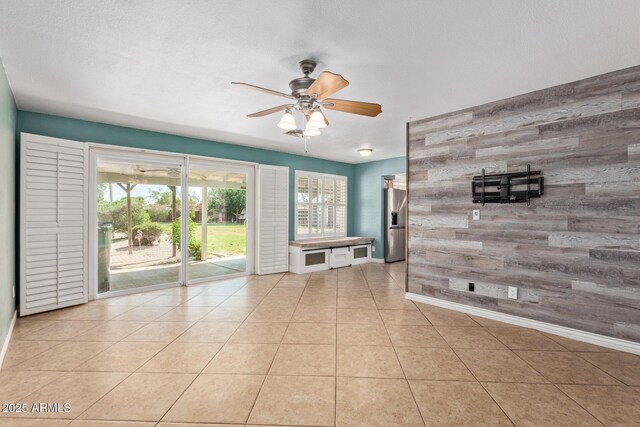 2161 E Harmony Cir, Mesa, AZ 85204 - tiled empty room featuring wooden walls, an accent wall, and a ceiling fan