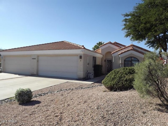 view of front of home featuring a garage, concrete driveway, stucco siding, and a tile roof